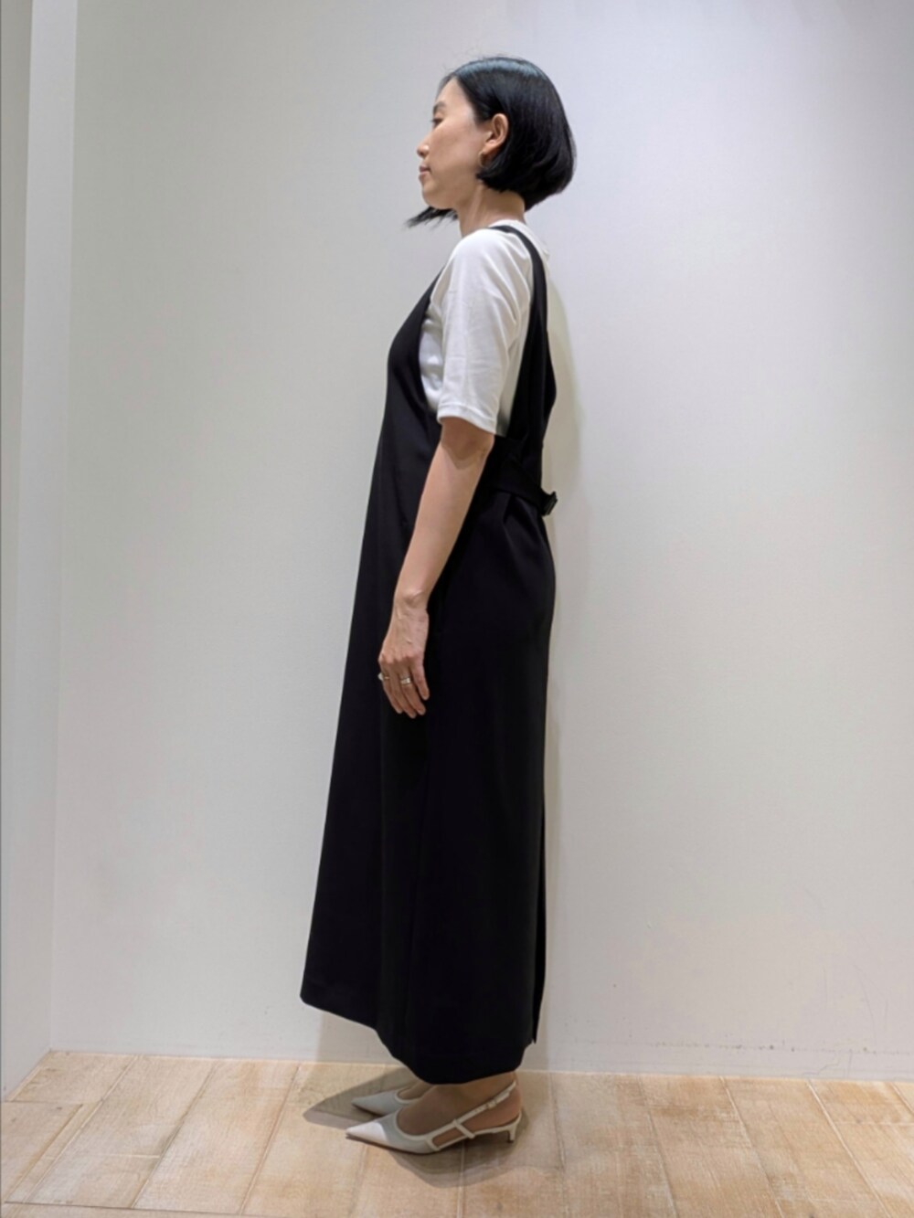 ホワイト系のTシャツ/カットソー、ブラック系のワンピース、ゴールド系のネックレスを着用したレディースの秋コーディネートの3枚目の写真