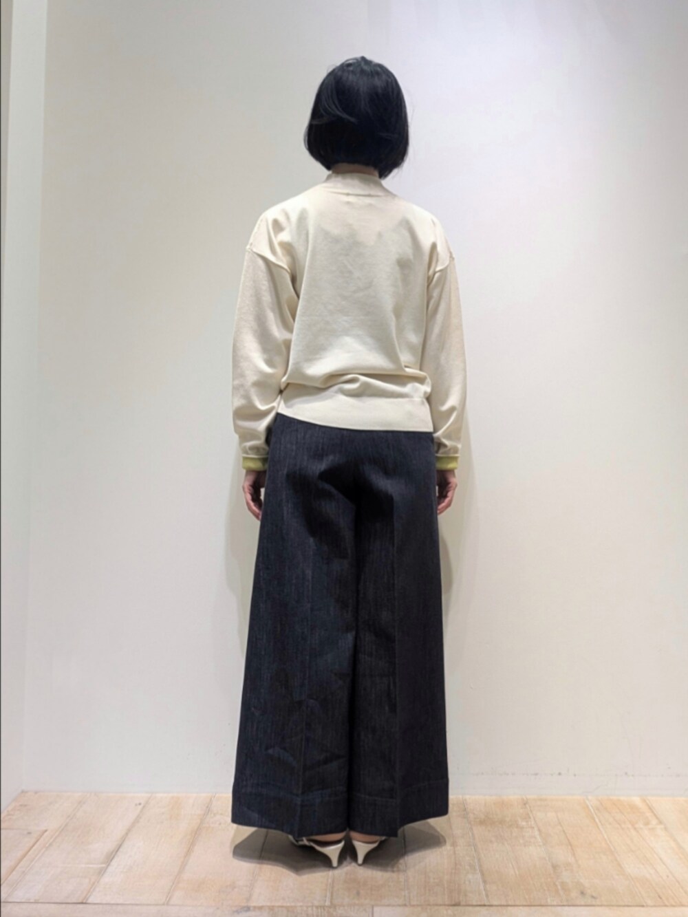 ホワイト系のニット/セーター、ブルー系のデニムパンツ、グリーン系のショルダーバッグを着用したレディースの冬コーディネートの5枚目の写真