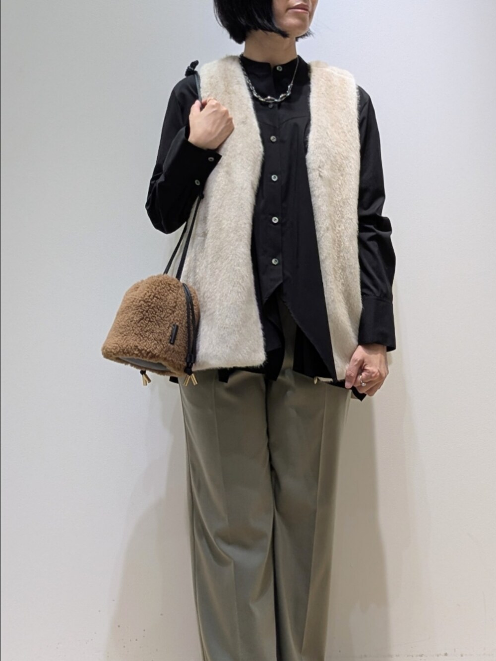 ブラック系のシャツ/ブラウス、ホワイト系のベスト、グリーン系のその他パンツを着用したレディースの秋コーディネートの2枚目の写真