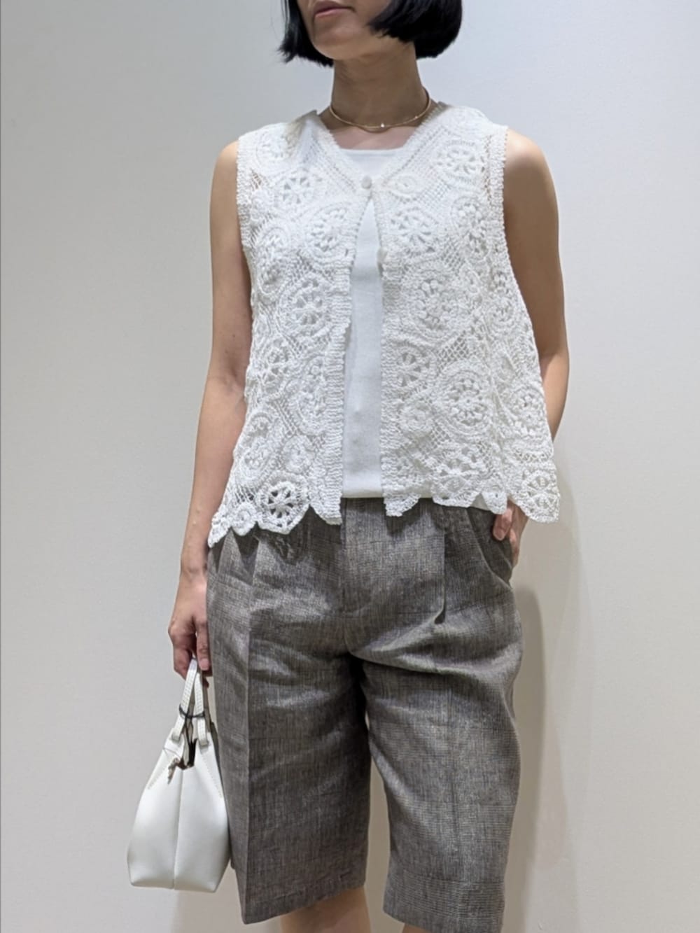 ホワイト系のタンクトップ、ホワイト系のベスト、ベージュ系のその他パンツを着用したレディースの春コーディネートの2枚目の写真