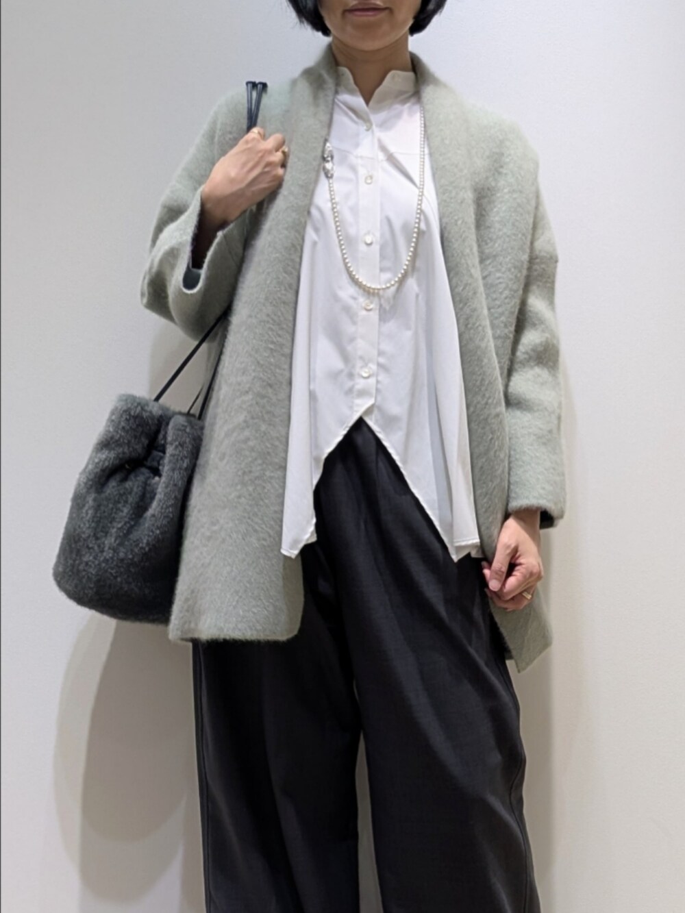 グリーン系のカーディガン/ボレロ、ホワイト系のシャツ/ブラウス、グレー系のその他パンツを着用したレディースの秋コーディネートの2枚目の写真