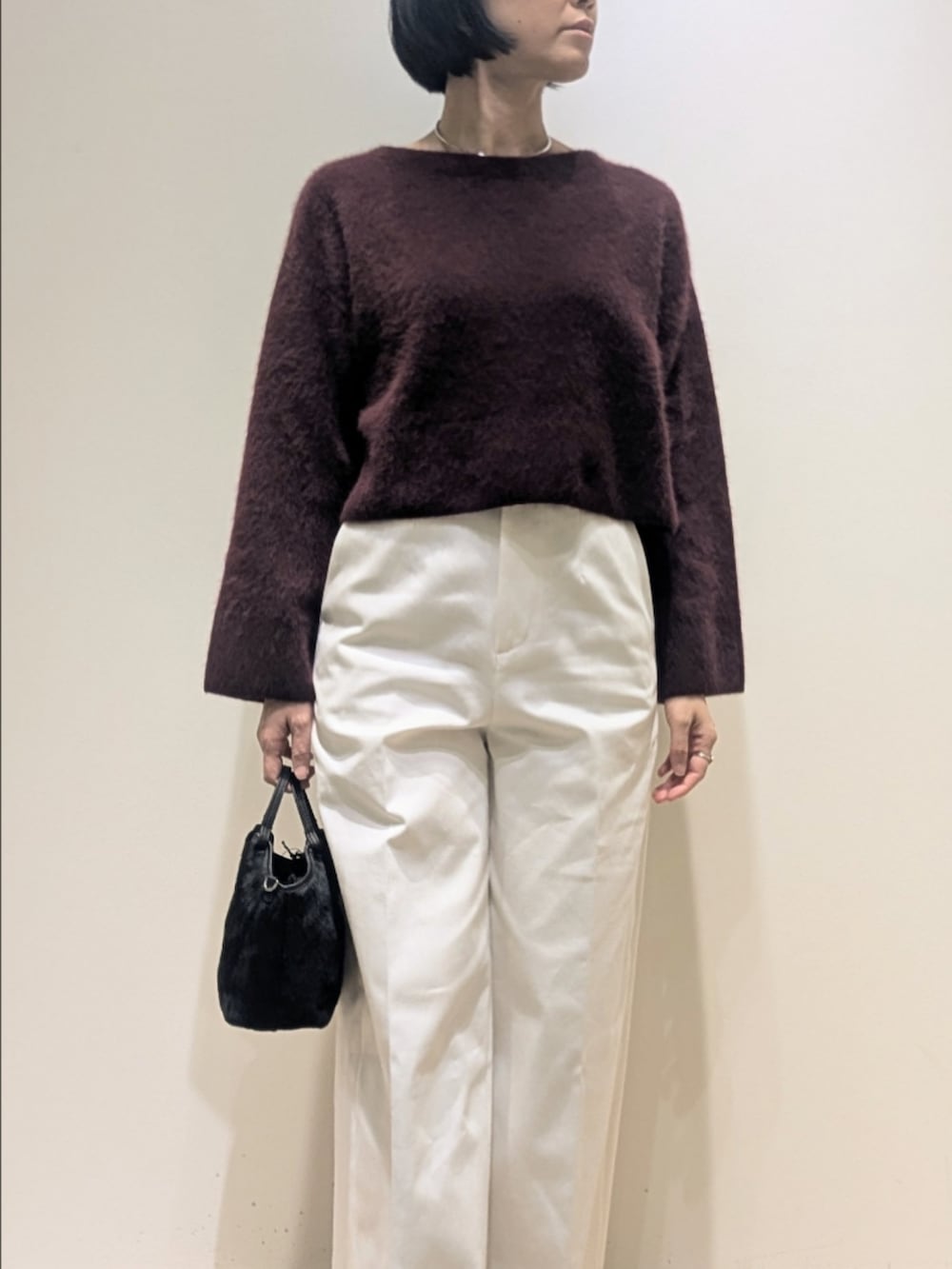 レッド系のニット/セーター、ホワイト系のデニムパンツを着用したレディースの冬コーディネートの3枚目の写真