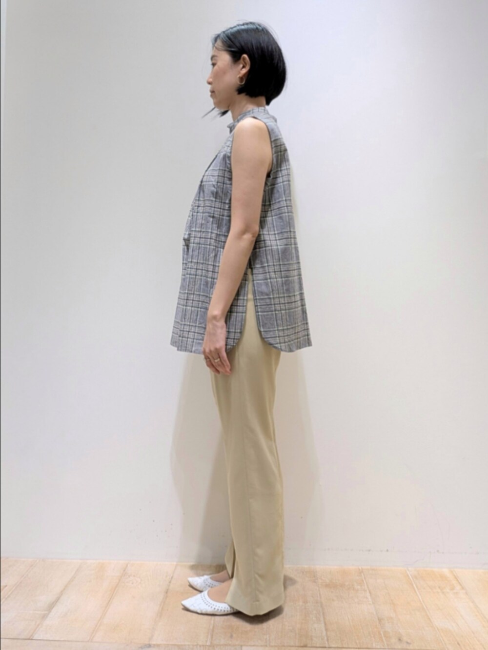 グリーン系のタンクトップ、イエロー系のスラックスを着用したレディースの夏コーディネートの3枚目の写真