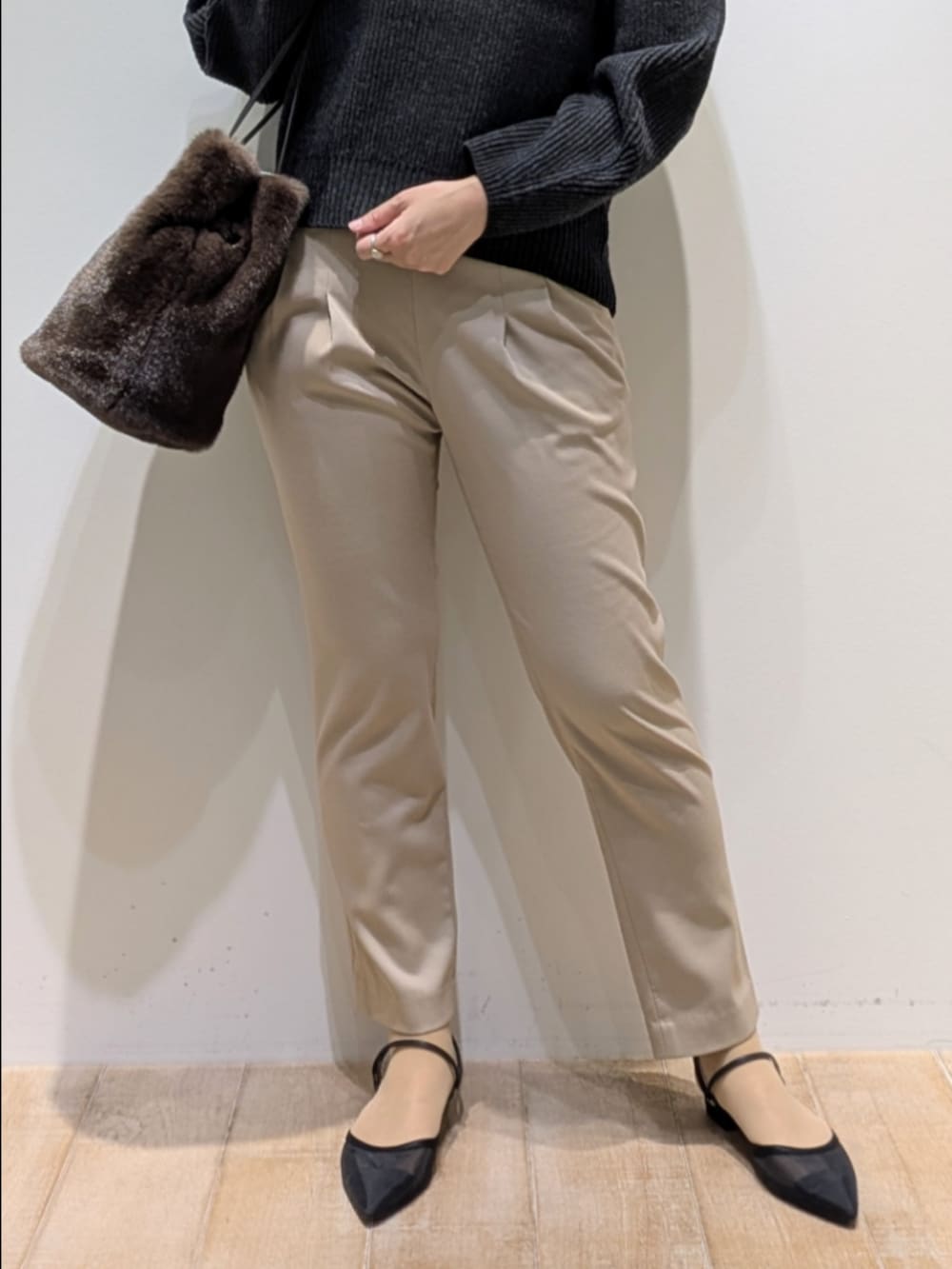 グレー系のニット/セーター、ベージュ系のその他パンツ、ブラウン系のショルダーバッグを着用したレディースの秋コーディネートの3枚目の写真