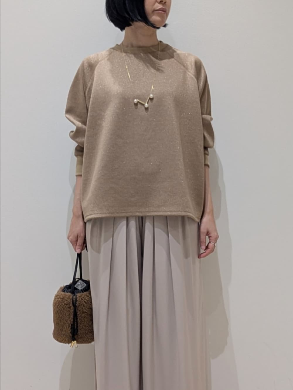 ブラウン系のスウェット、ベージュ系のその他パンツを着用したレディースの冬コーディネートの2枚目の写真