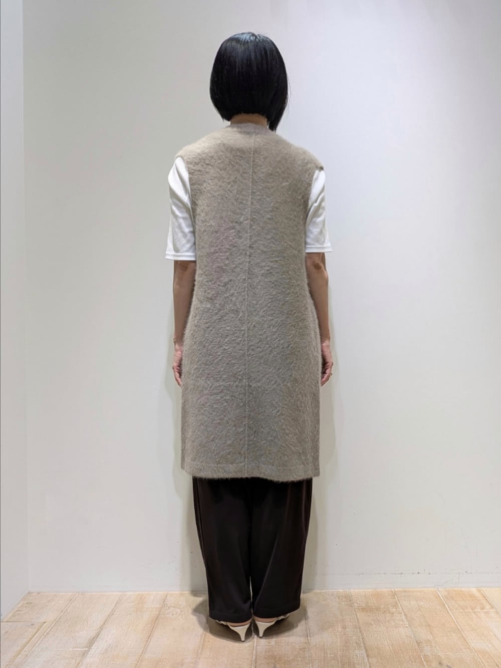 ホワイト系のTシャツ/カットソー、ブラウン系のベスト、ブラウン系のその他パンツを着用したレディースの秋コーディネートの5枚目の写真