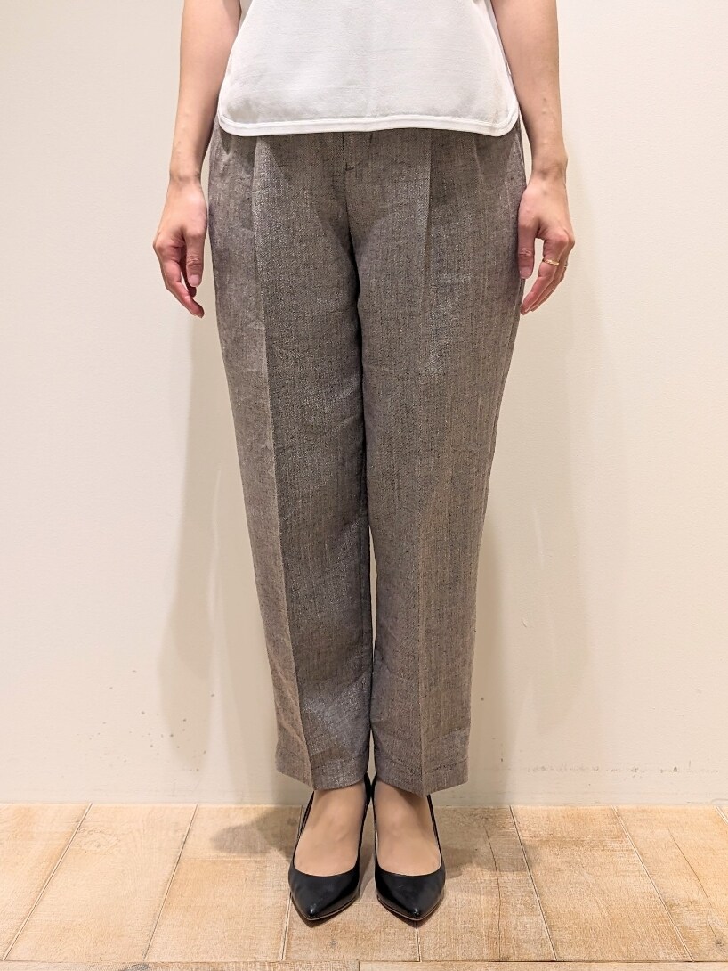 ホワイト系のテーラードジャケット、ホワイト系のニット/セーター、グレー系のスラックスを着用したレディースの春コーディネートの2枚目の写真