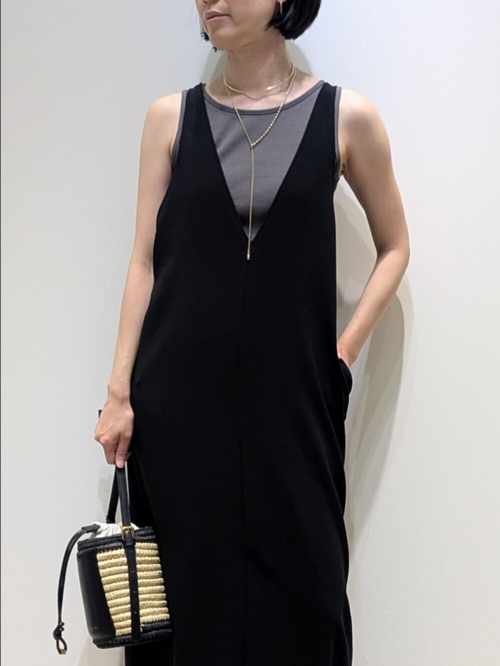 ブラック系のワンピース、ゴールド系のネックレス、ゴールド系のネックレスを着用したレディースの夏コーディネートの2枚目の写真