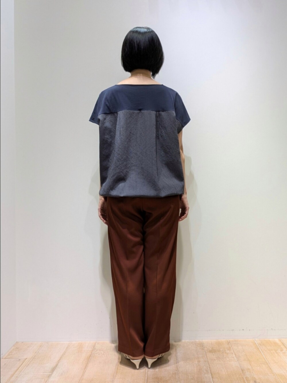 ブラウン系のその他パンツ、ブルー系のTシャツ/カットソー、ゴールド系のネックレスを着用したレディースの秋コーディネートの5枚目の写真