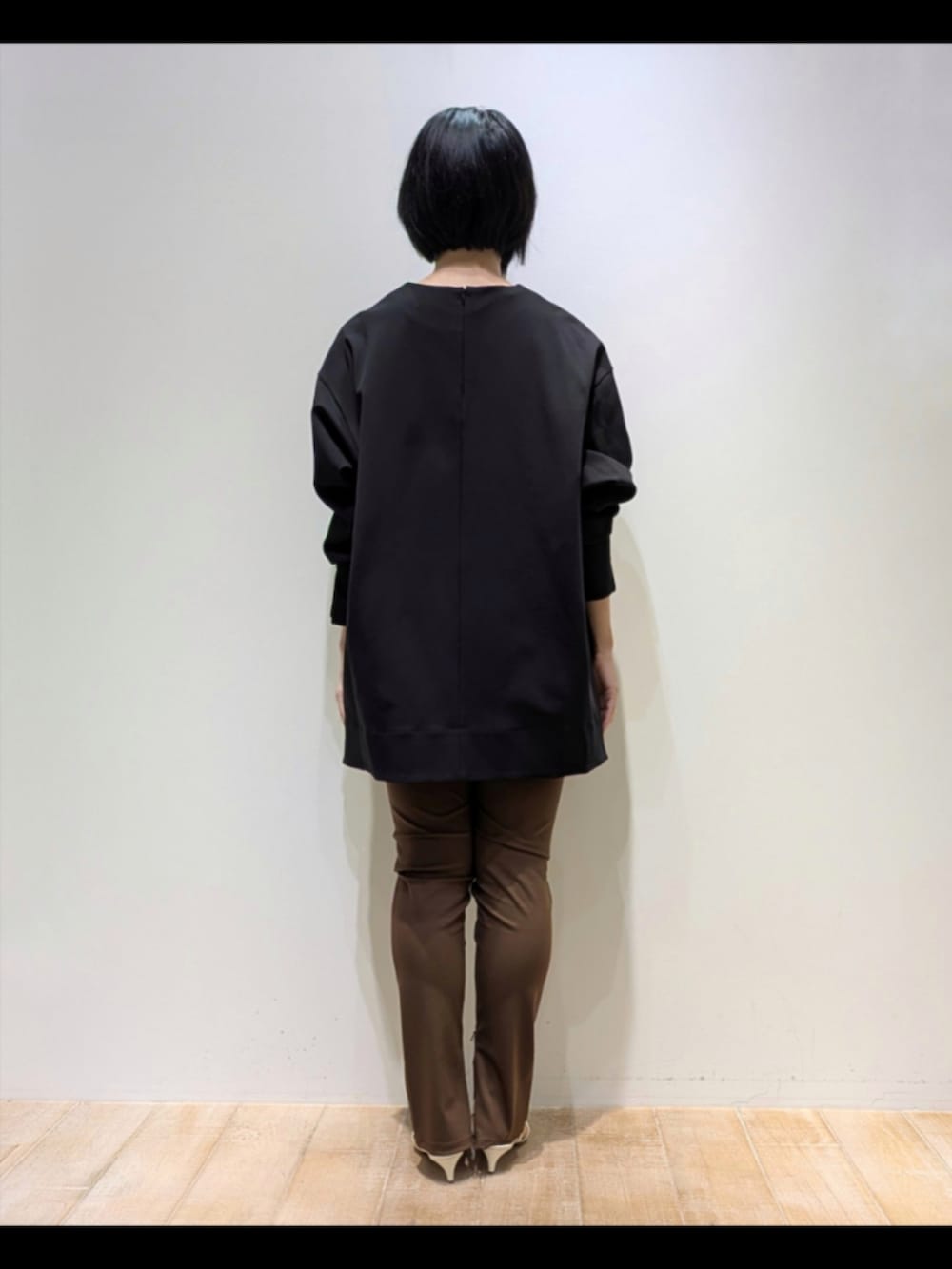 ブラック系のスウェット、ブラウン系のその他パンツ、ホワイト系のショルダーバッグを着用したレディースの秋コーディネートの5枚目の写真