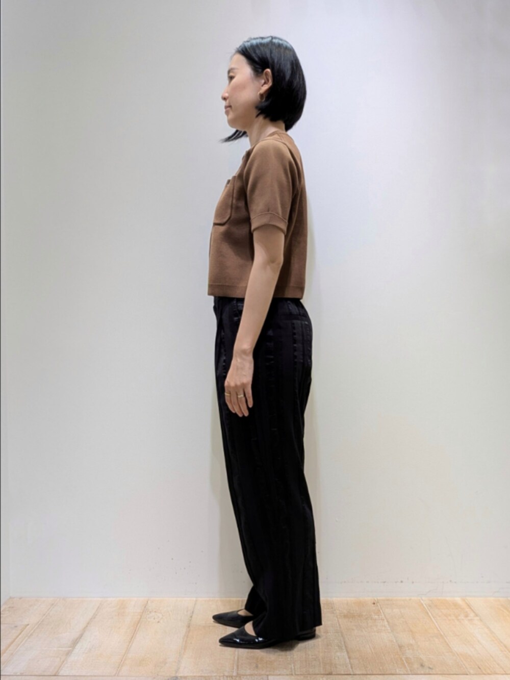 ブラウン系のTシャツ/カットソー、ブラック系のその他パンツ、ブラウン系のショルダーバッグを着用したレディースの秋コーディネートの4枚目の写真