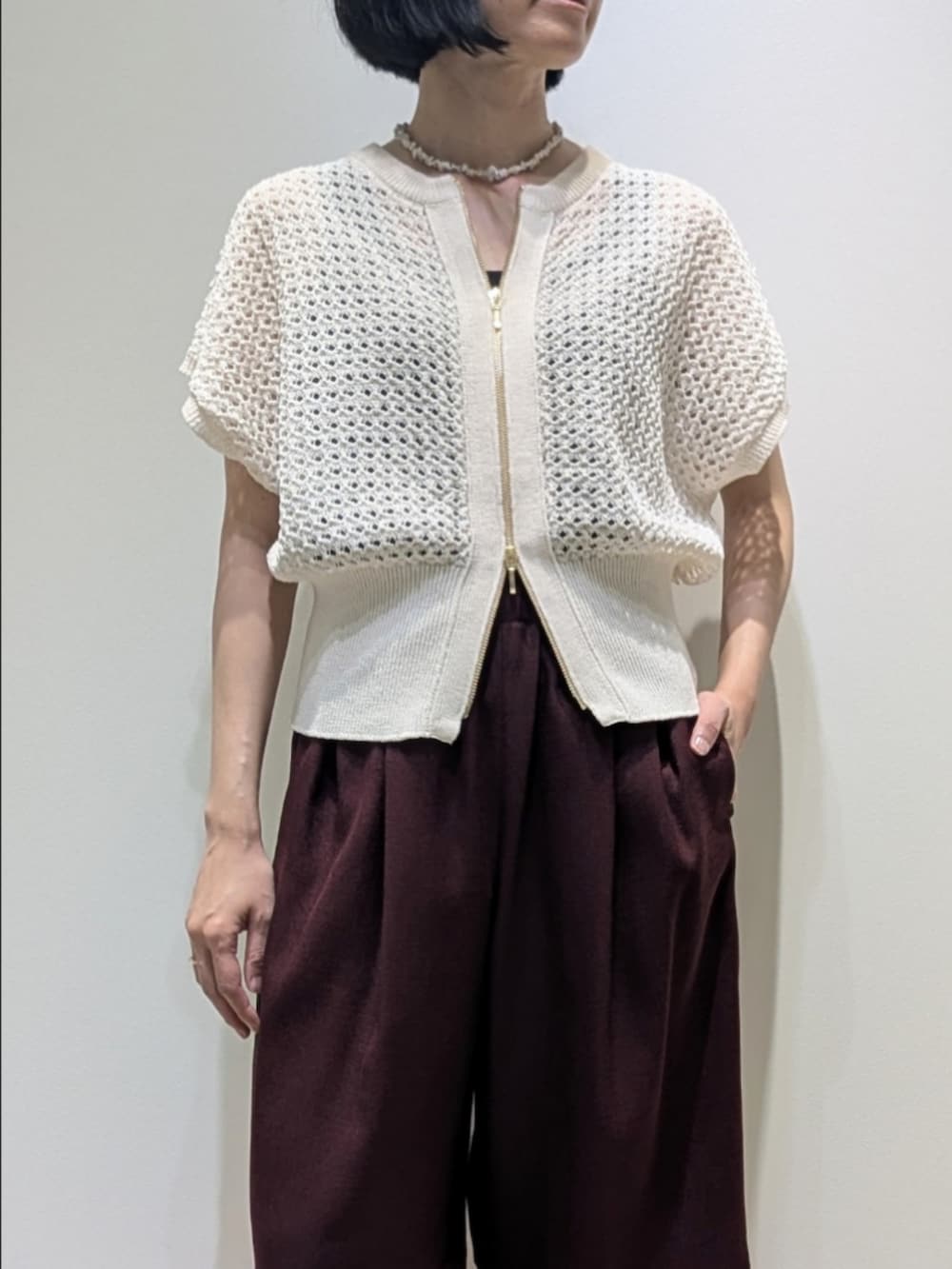 レッド系のその他パンツ、ホワイト系のニット/セーター、ホワイト系のネックレスを着用したレディースの春コーディネートの2枚目の写真