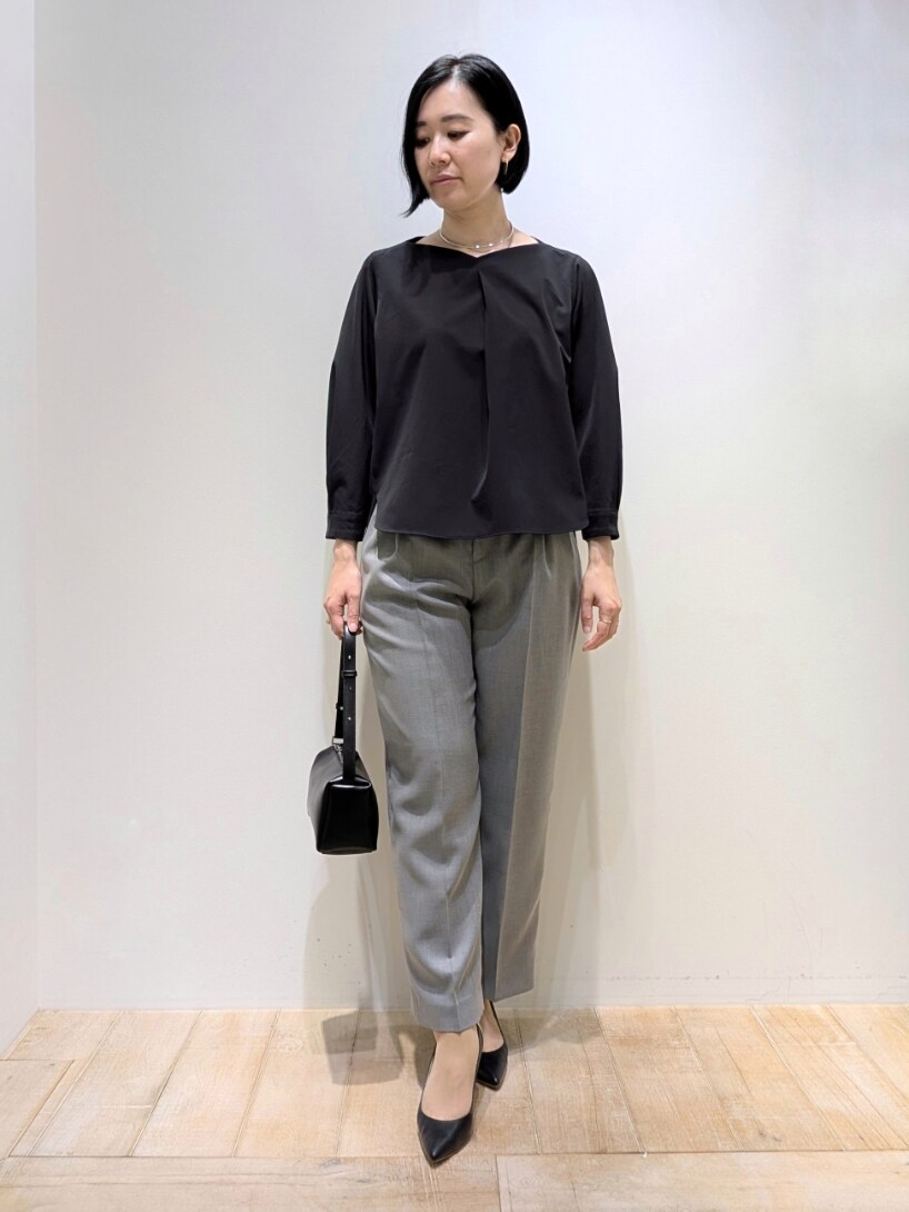 ブラック系のシャツ/ブラウス、グレー系のスラックスを着用したレディースの春コーディネートの5枚目の写真
