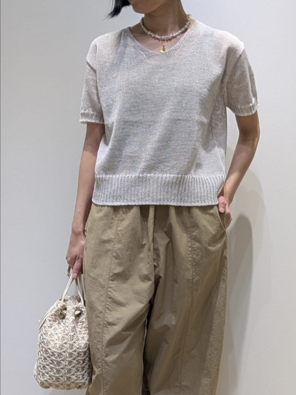 ホワイト系のニット/セーター、ベージュ系のその他パンツ、ホワイト系のショルダーバッグを着用したレディースの春コーディネートの2枚目の写真