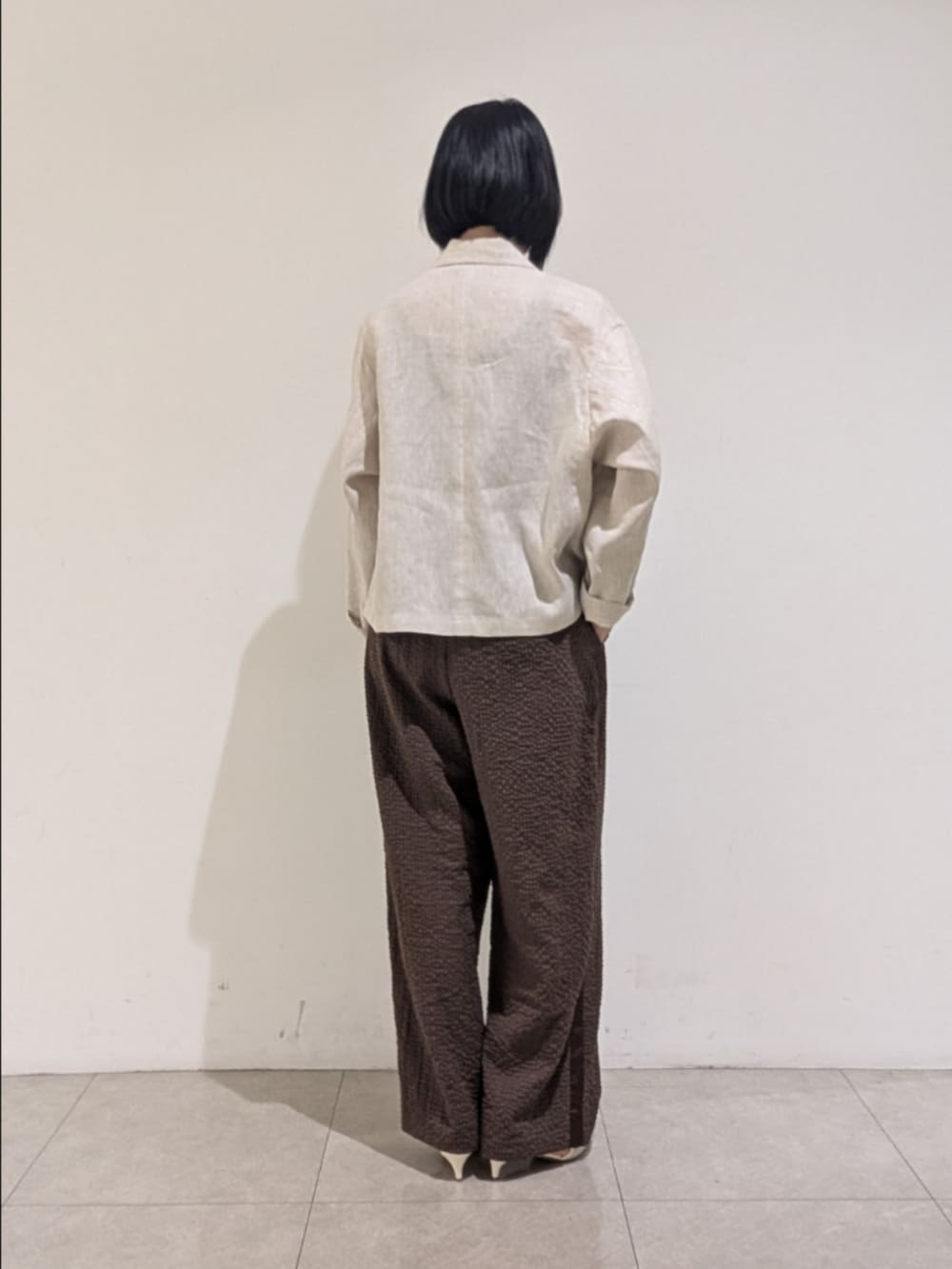 ベージュ系のテーラードジャケット、ブラウン系のその他パンツ、シルバー系のネックレスを着用したレディースの秋コーディネートの5枚目の写真