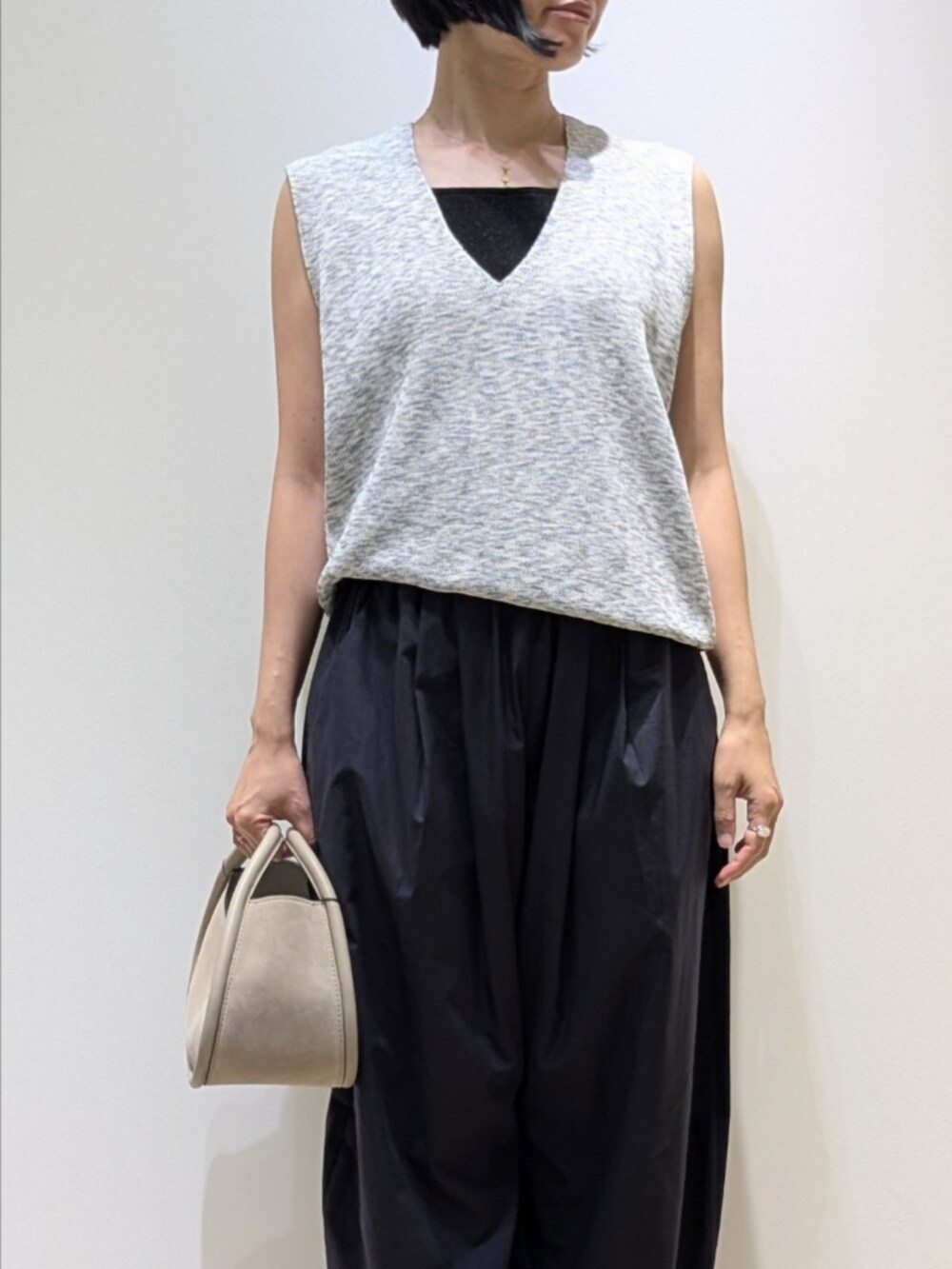 グレー系のベスト、ブラック系のタンクトップ、ブルー系のカーゴパンツを着用したレディースの夏コーディネートの2枚目の写真