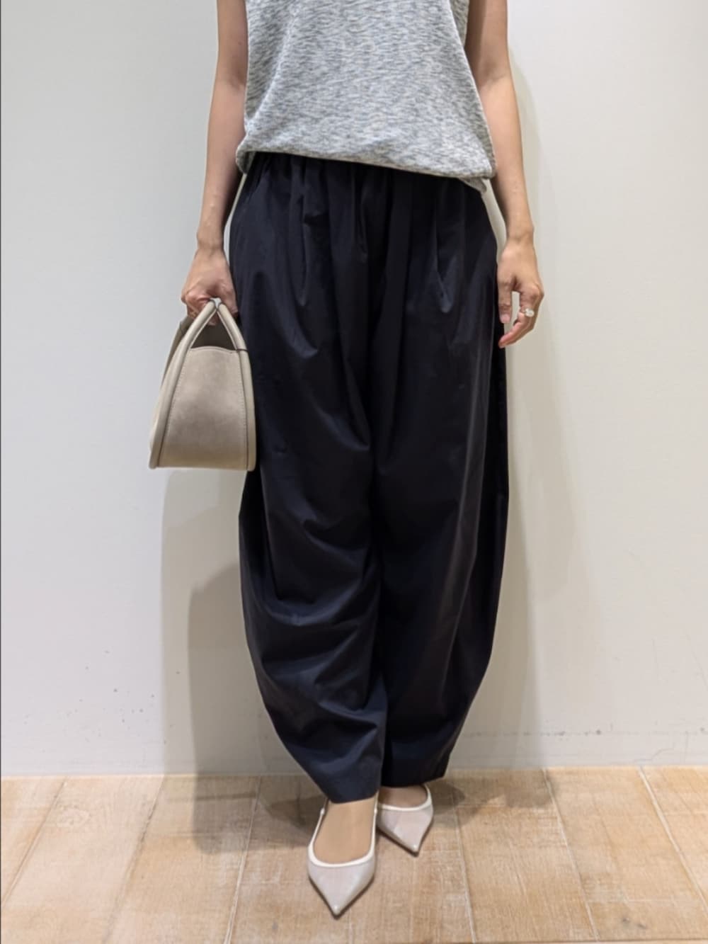 グレー系のベスト、ブラック系のタンクトップ、ブルー系のカーゴパンツを着用したレディースの夏コーディネートの3枚目の写真