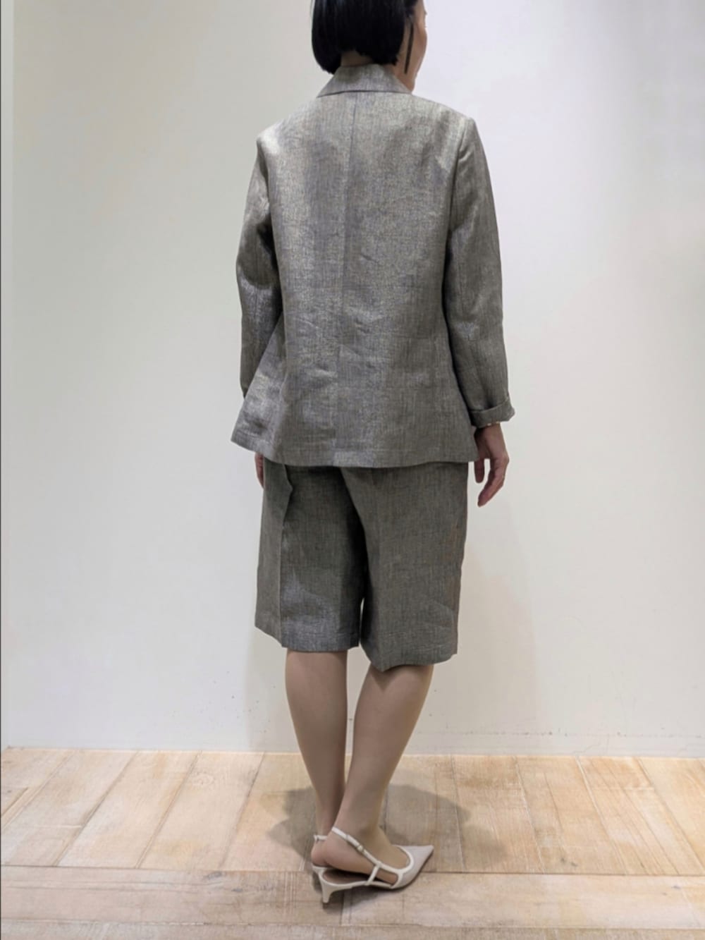 ベージュ系のテーラードジャケット、ベージュ系のその他パンツ、ホワイト系のタンクトップを着用したレディースの春コーディネートの5枚目の写真