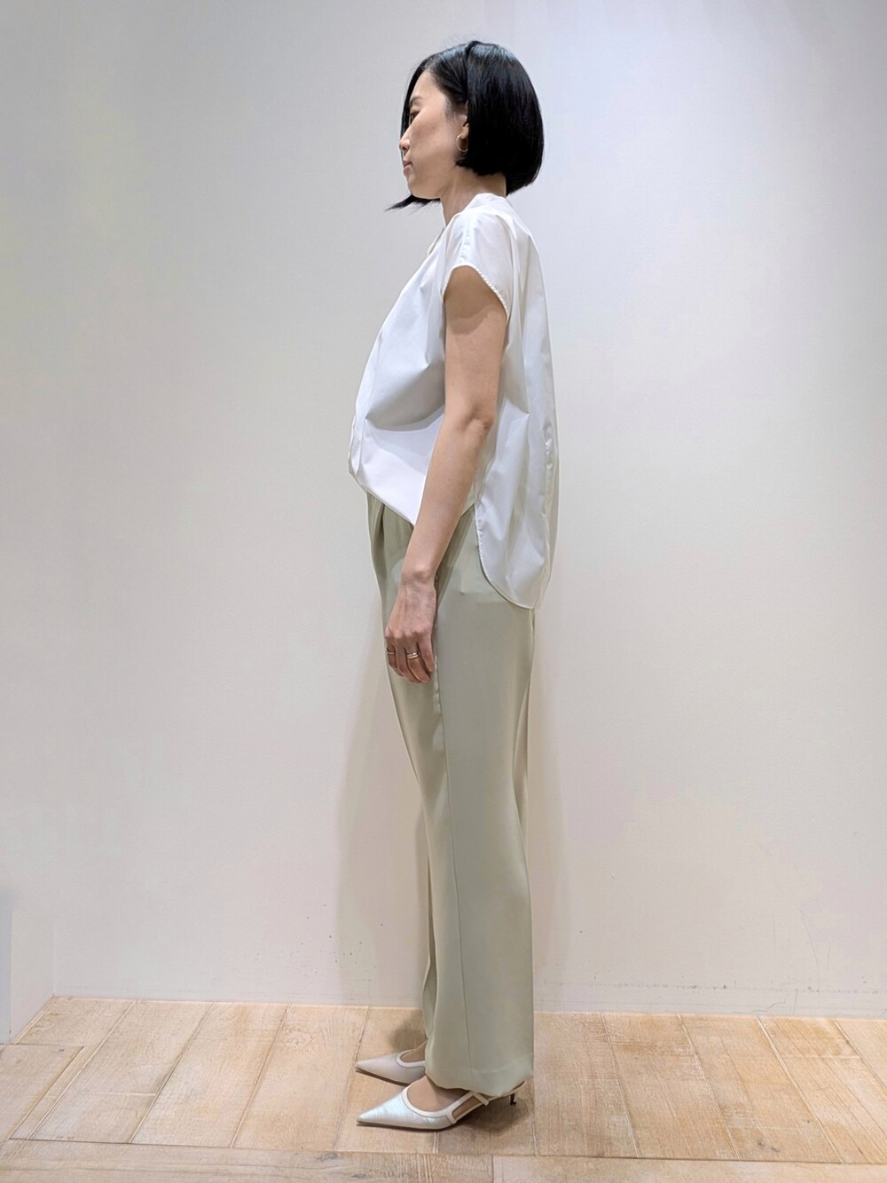 グリーン系のスラックス、ホワイト系のシャツ/ブラウスを着用したレディースの夏コーディネートの3枚目の写真