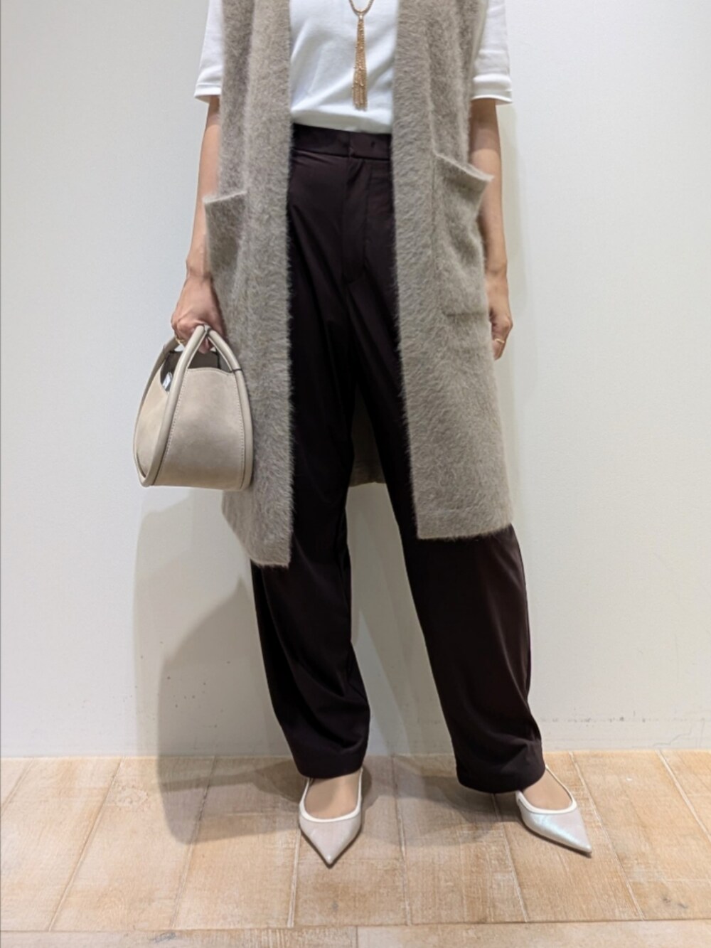 ホワイト系のTシャツ/カットソー、ブラウン系のベスト、ブラウン系のその他パンツを着用したレディースの秋コーディネートの3枚目の写真