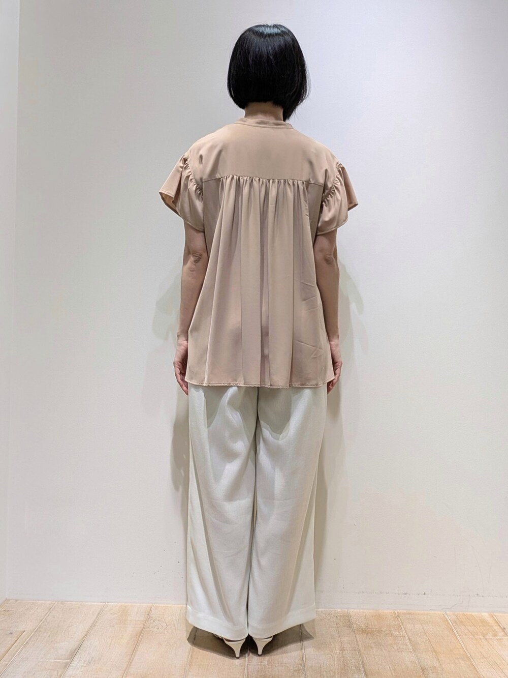 ホワイト系のスラックス、ベージュ系のシャツ/ブラウスを着用したレディースの夏コーディネートの4枚目の写真