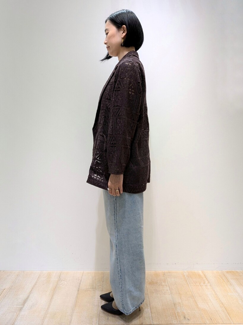 ブラウン系のテーラードジャケット、ベージュ系のタンクトップ、ブルー系のデニムパンツを着用したレディースの夏コーディネートの2枚目の写真