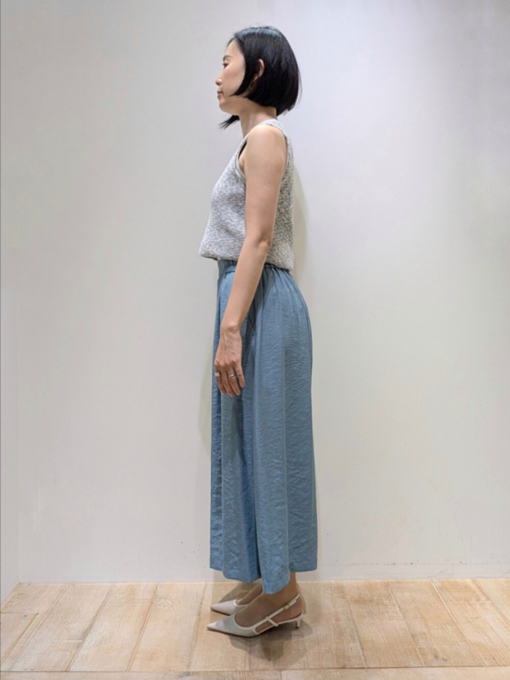 グリーン系のその他パンツ、グレー系のベスト、ホワイト系のタンクトップを着用したレディースの夏コーディネートの3枚目の写真