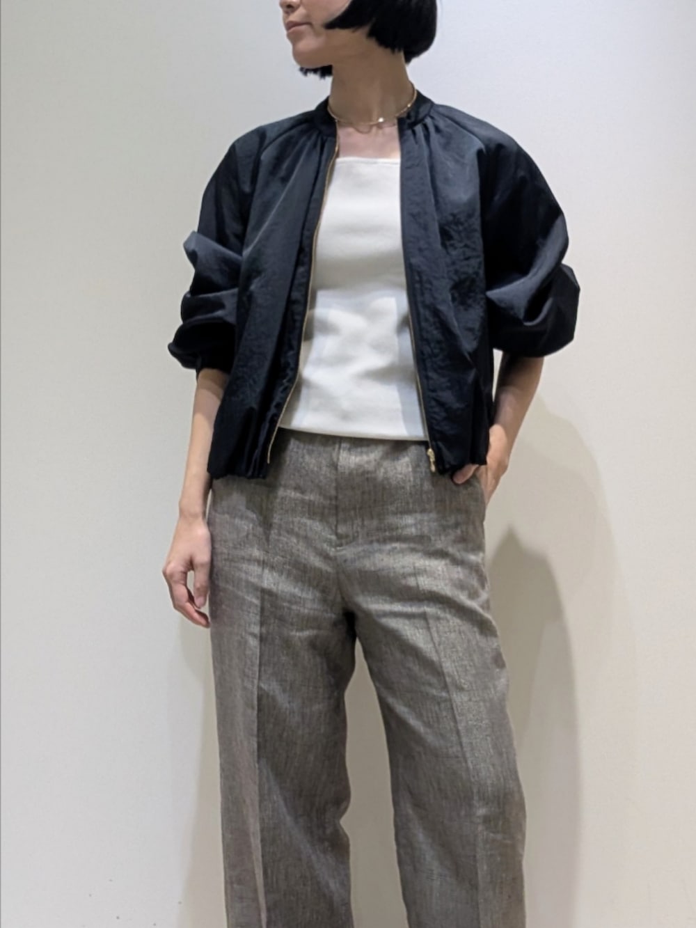 ブルー系のブルゾン、ホワイト系のタンクトップ、ベージュ系のその他パンツを着用したレディースの春コーディネートの2枚目の写真