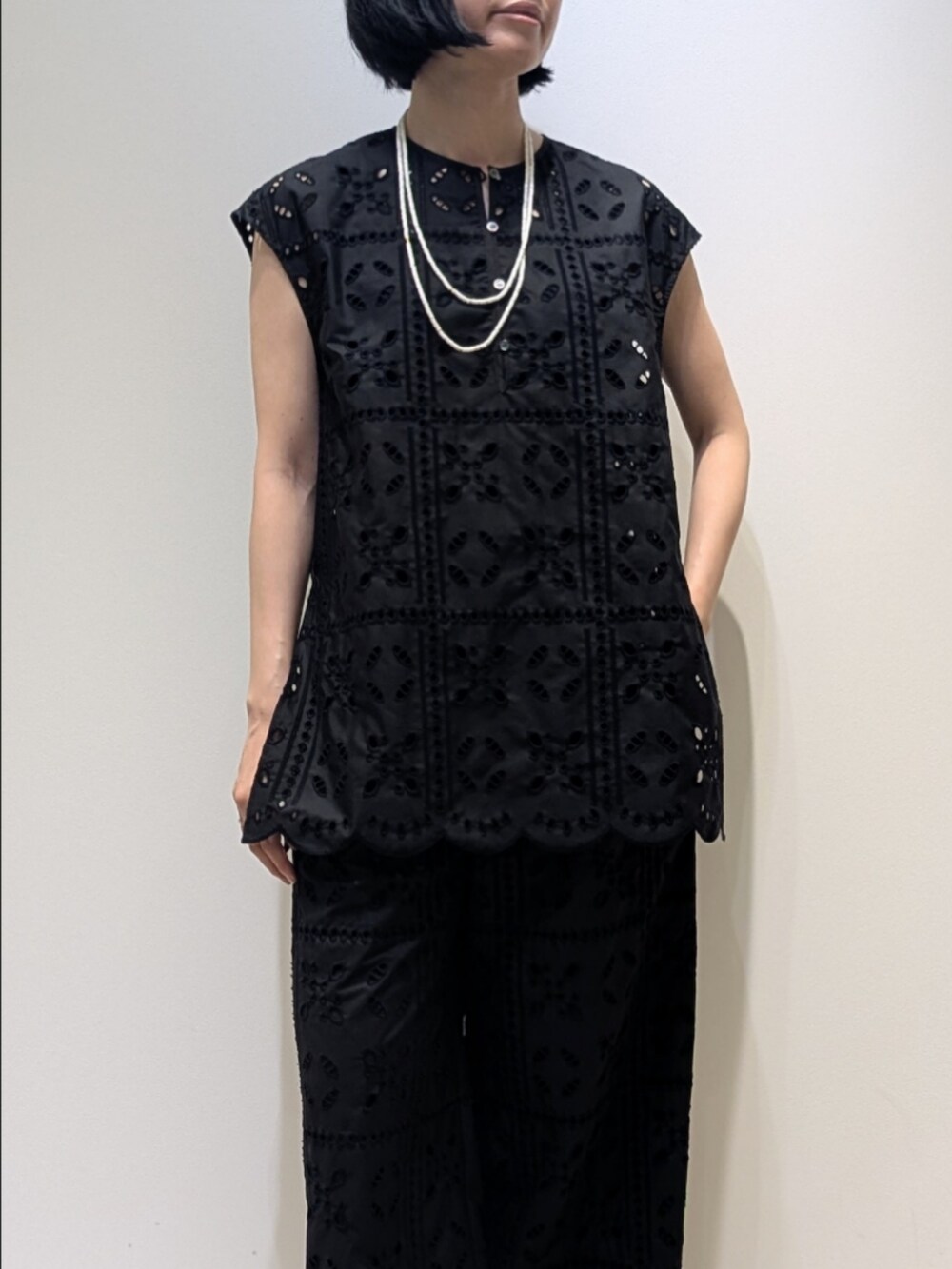 ブラック系のシャツ/ブラウス、ブラック系のその他パンツ、ホワイト系のネックレスを着用したレディースの夏コーディネートの2枚目の写真