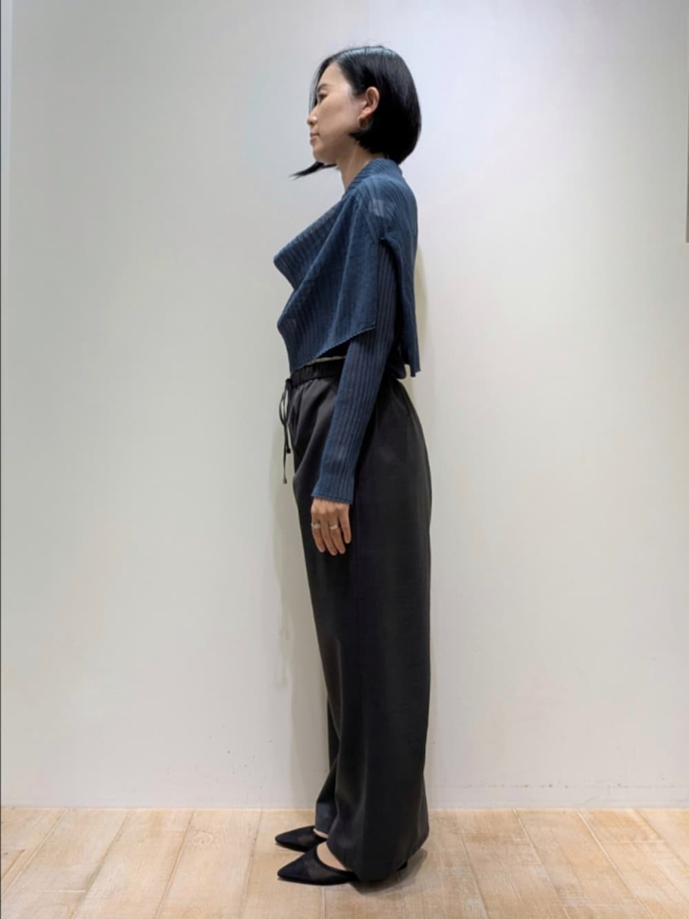 ブルー系のニット/セーター、グレー系のその他パンツ、シルバー系のトートバッグを着用したレディースの秋コーディネートの4枚目の写真