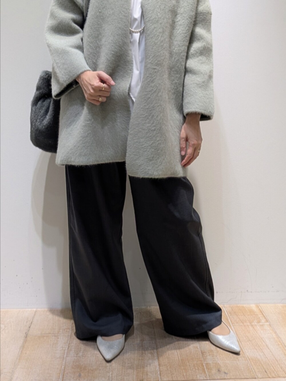 グリーン系のカーディガン/ボレロ、ホワイト系のシャツ/ブラウス、グレー系のその他パンツを着用したレディースの秋コーディネートの3枚目の写真