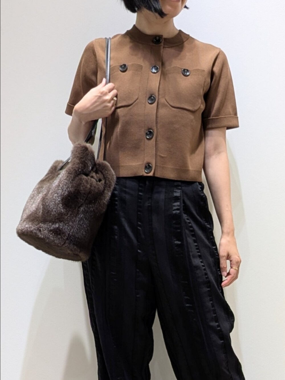 ブラウン系のTシャツ/カットソー、ブラック系のその他パンツ、ブラウン系のショルダーバッグを着用したレディースの秋コーディネートの2枚目の写真