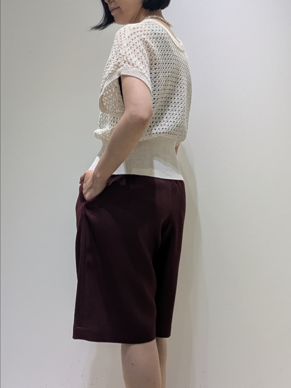 レッド系のその他パンツ、ホワイト系のニット/セーター、ホワイト系のネックレスを着用したレディースの春コーディネートの4枚目の写真