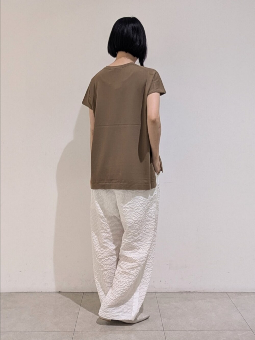 グレー系のニット/セーター、ホワイト系のその他パンツ、ゴールド系のネックレスを着用したレディースの夏コーディネートの5枚目の写真