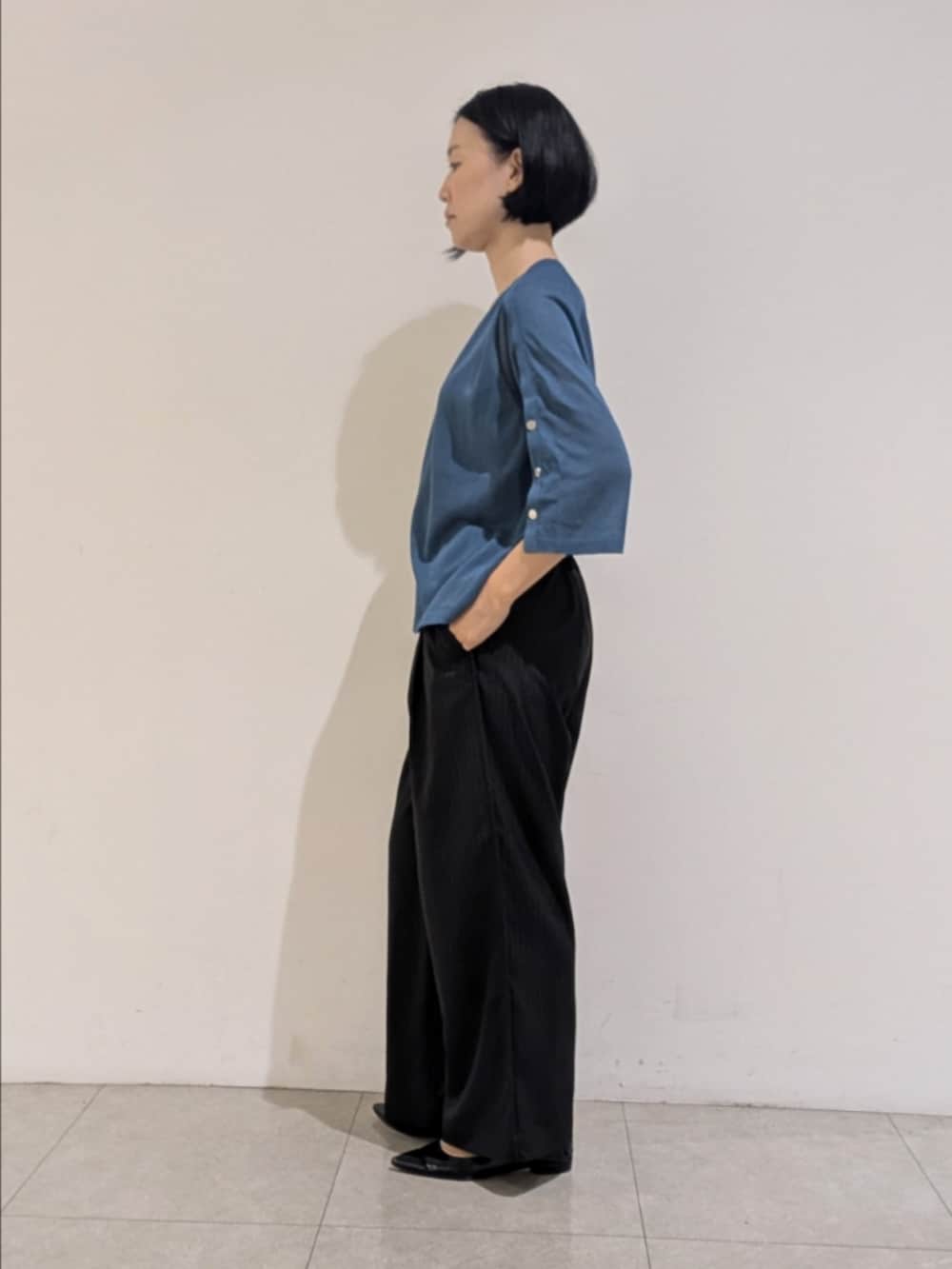 ブルー系のニット/セーター、ブラック系のその他パンツ、シルバー系のネックレスを着用したレディースの秋コーディネートの4枚目の写真