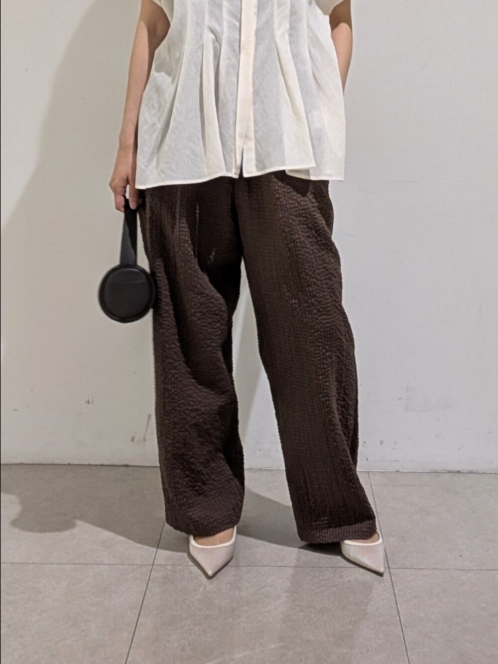 ホワイト系のシャツ/ブラウス、ブラウン系のその他パンツ、ゴールド系のネックレスを着用したレディースの夏コーディネートの3枚目の写真