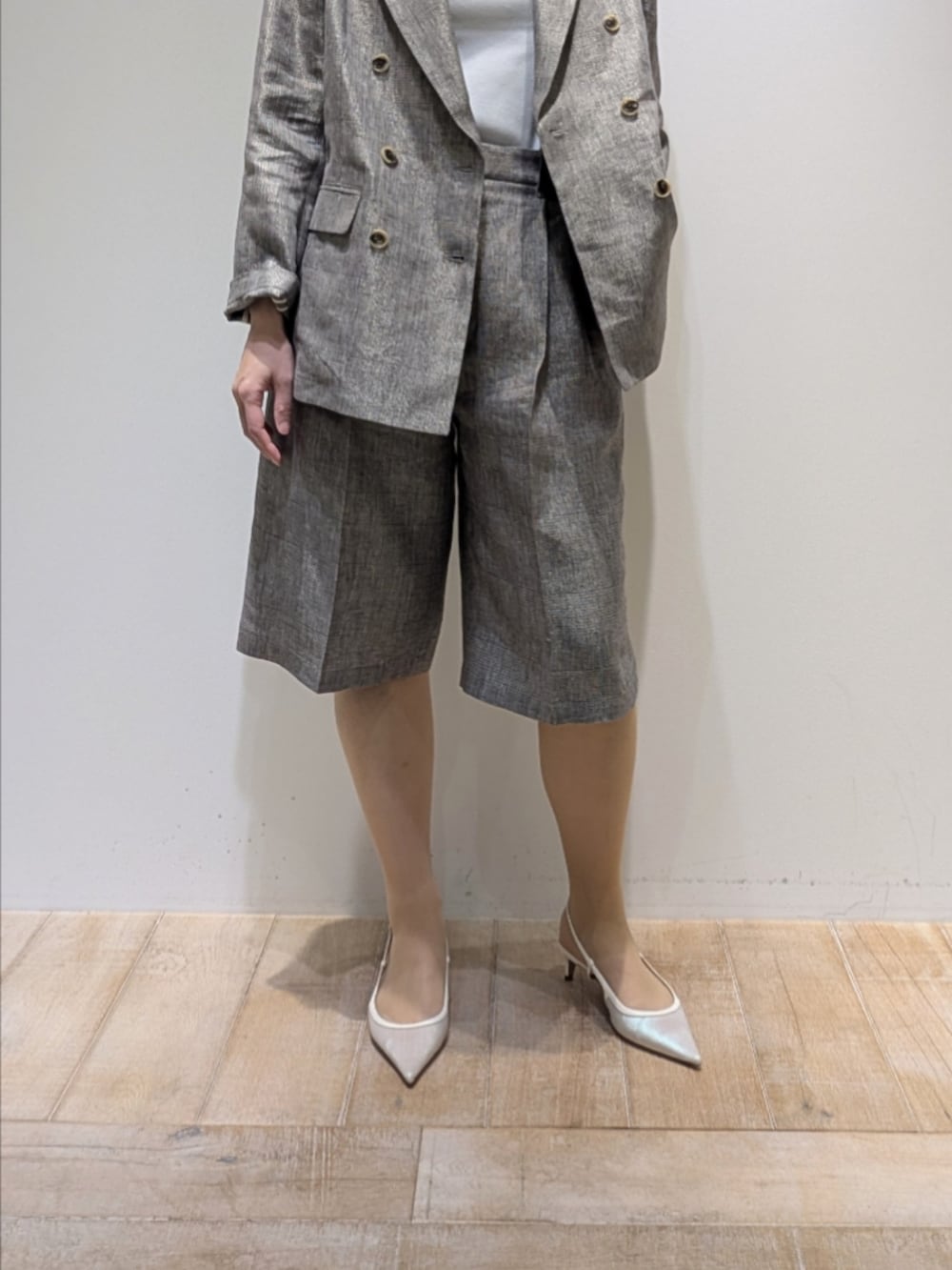 ベージュ系のテーラードジャケット、ベージュ系のその他パンツ、ホワイト系のタンクトップを着用したレディースの春コーディネートの3枚目の写真