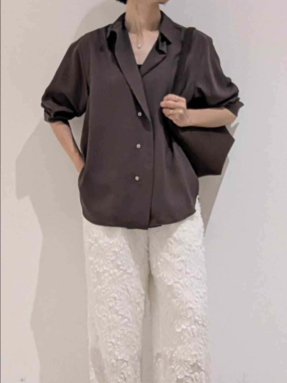 ブラウン系のシャツ/ブラウス、ホワイト系のその他パンツ、ブラウン系のトートバッグを着用したレディースの秋コーディネートの2枚目の写真