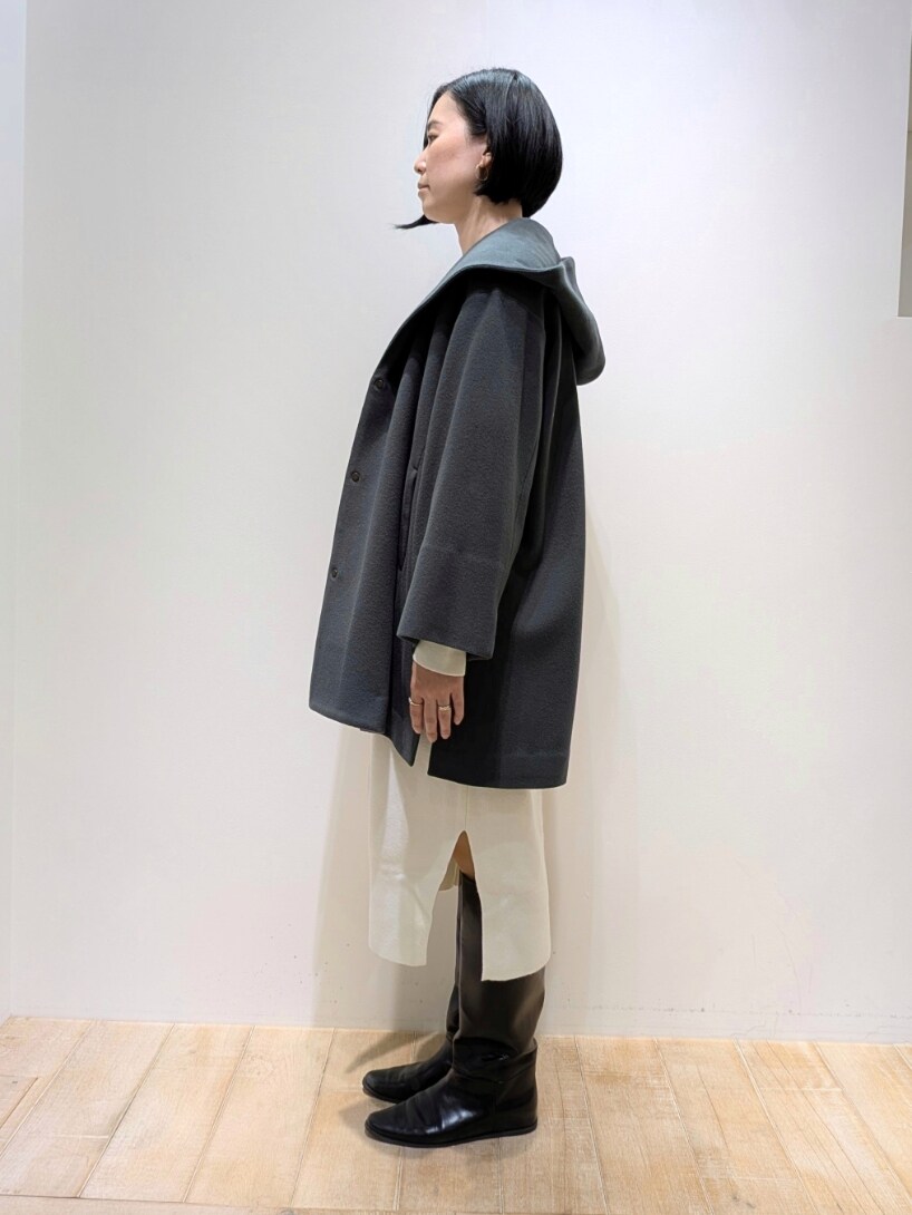 グリーン系のノーカラーコート、ホワイト系のワンピースを着用したレディースの冬コーディネートの2枚目の写真