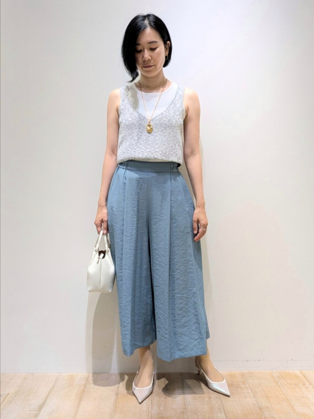 グリーン系のその他パンツ、グレー系のベスト、ホワイト系のタンクトップを着用したレディースの夏コーディネートの5枚目の写真