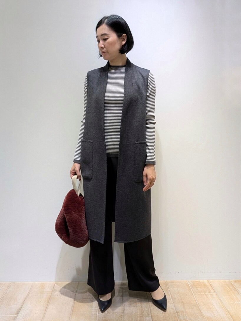 ベージュ系のベスト、その他のニット/セーター、ブラック系のスラックスを着用したレディースの秋コーディネートの4枚目の写真