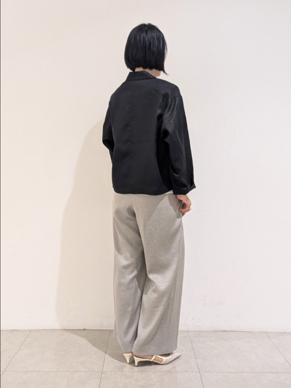 ブラック系のテーラードジャケット、グレー系のその他パンツ、ホワイト系のタンクトップを着用したレディースの夏コーディネートの5枚目の写真