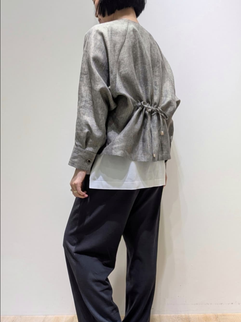 ベージュ系のブルゾン、グレー系のその他パンツ、ホワイト系のニット/セーターを着用したレディースの春コーディネートの4枚目の写真