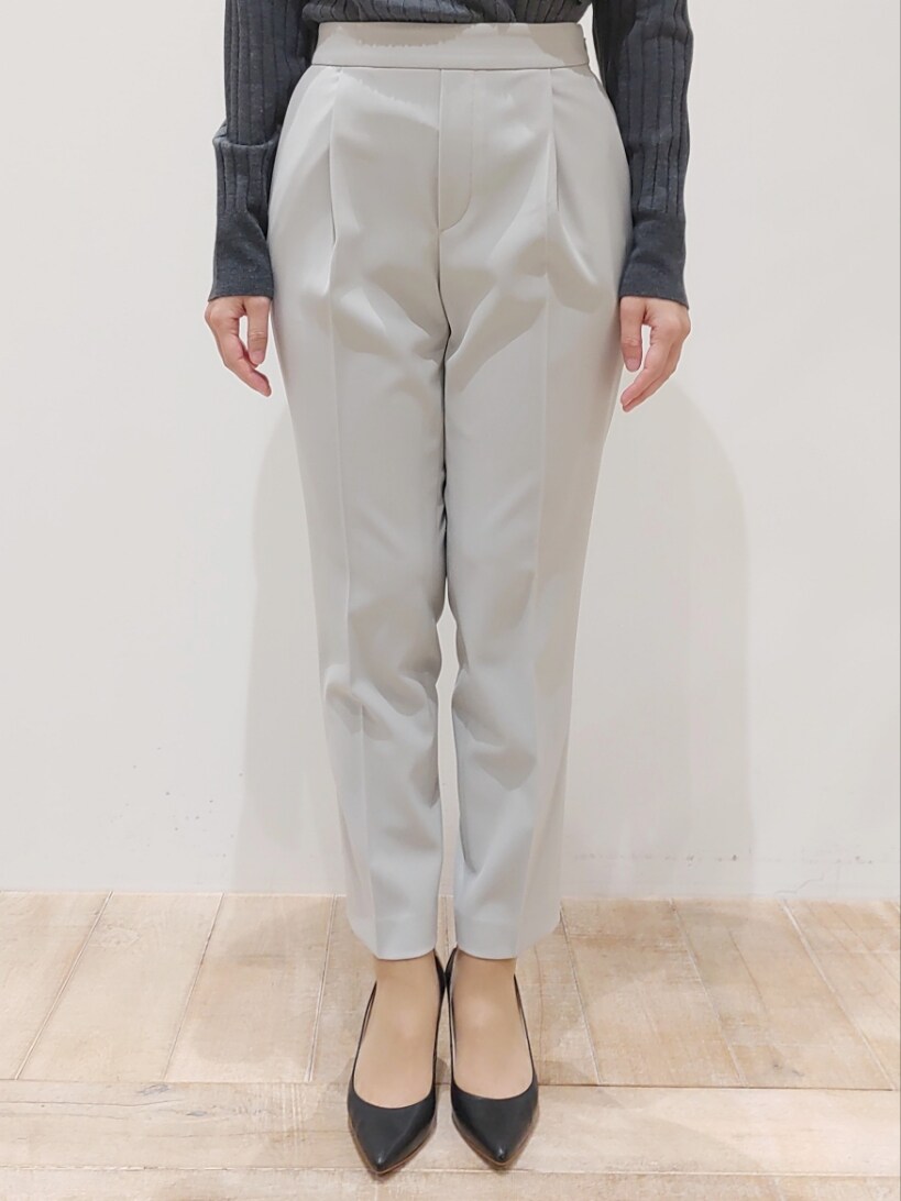 グレー系のニット/セーター、ベージュ系のスラックスを着用したレディースの冬コーディネートの2枚目の写真