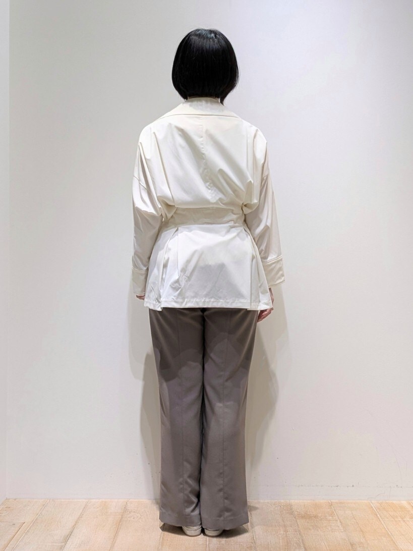 ホワイト系のトレンチコート、ホワイト系のTシャツ/カットソー、ブラウン系のスラックスを着用したレディースの春コーディネートの3枚目の写真