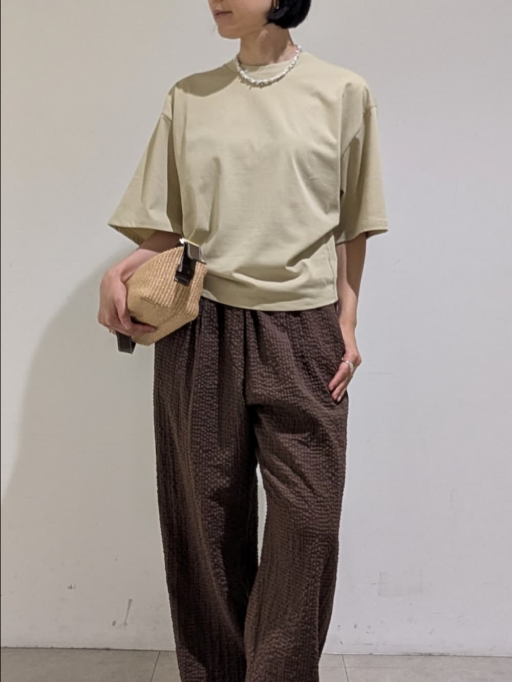 グリーン系のTシャツ/カットソー、ブラウン系のその他パンツ、ホワイト系のネックレスを着用したレディースの夏コーディネートの2枚目の写真