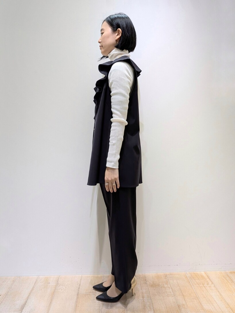 ブルー系のベスト、ブルー系のスラックス、ホワイト系のニット/セーターを着用したレディースの冬コーディネートの2枚目の写真