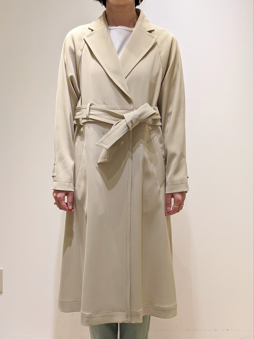 ホワイト系のニット/セーター、グリーン系のデニムパンツ、ベージュ系のトレンチコートを着用したレディースの冬コーディネートの2枚目の写真