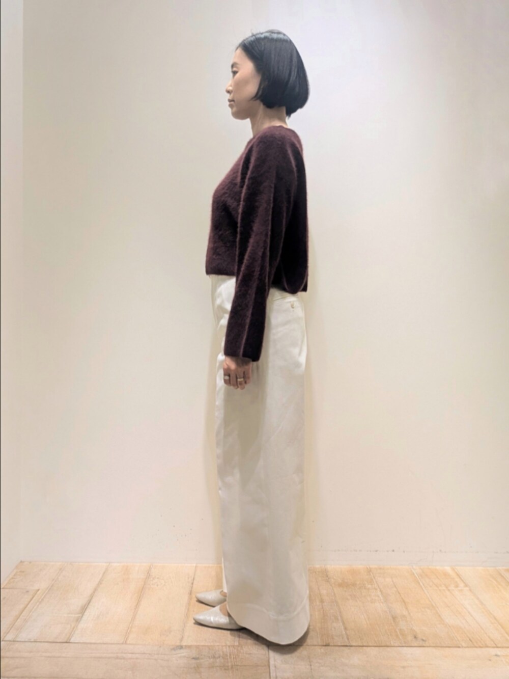 レッド系のニット/セーター、ホワイト系のデニムパンツを着用したレディースの冬コーディネートの4枚目の写真