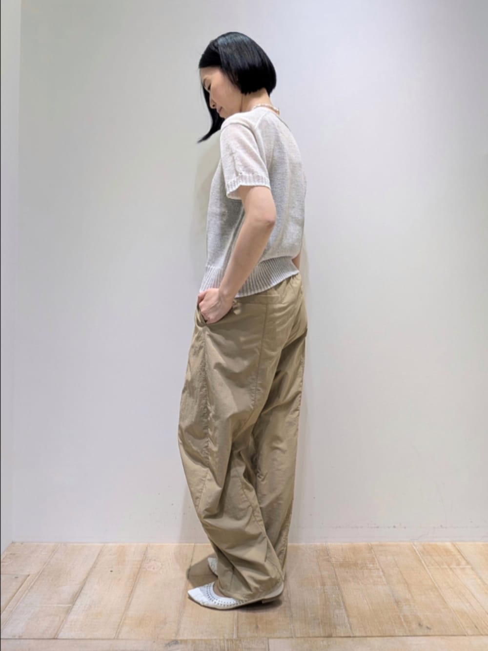 ホワイト系のニット/セーター、ベージュ系のその他パンツ、ホワイト系のショルダーバッグを着用したレディースの春コーディネートの4枚目の写真